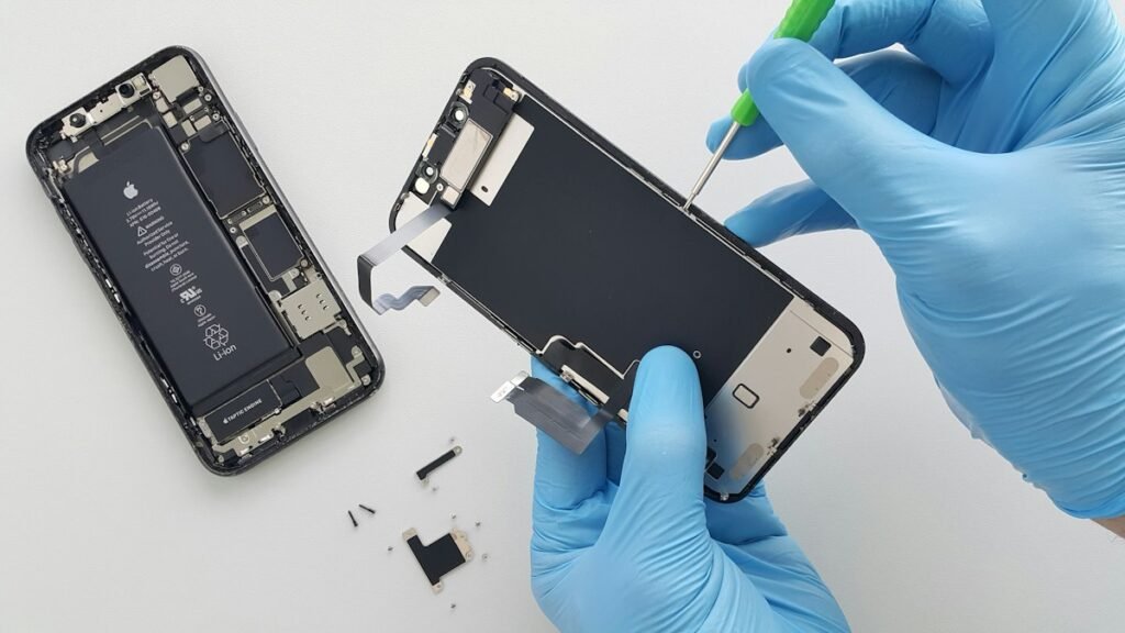 Technician replacing a smartphone screen with precision tools
