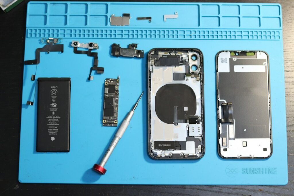 Phone parts and service tools laid out on an anti-static mat